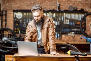 Man standing working on laptop