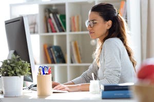 Pretty young business woman working with her computer in the office