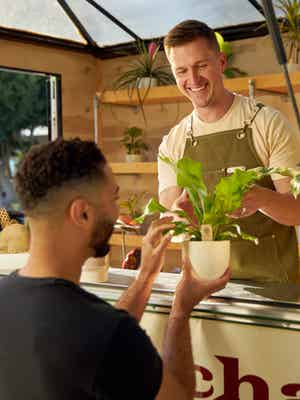 A happy man purchasing a plant at a store