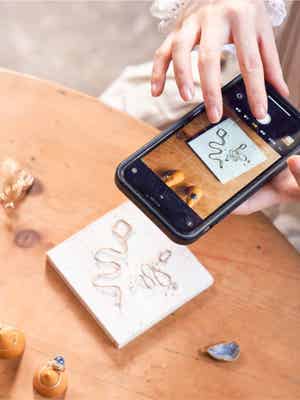 Person taking of their work with a smartphone